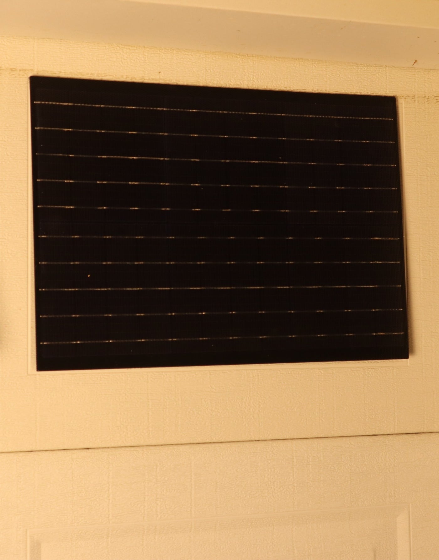 Zula's 75W solar panel mounted on a garage door window